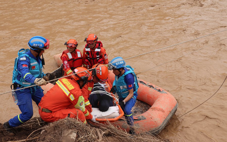 消防救援人員在慶城縣翟家河鄉轉移受災群眾。甘肅省森林消防總隊供圖