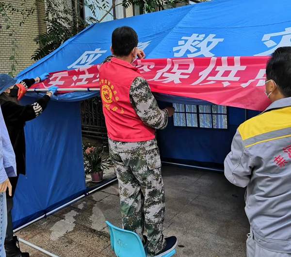 志愿者搭建保供點帳篷。冉麗蘭攝