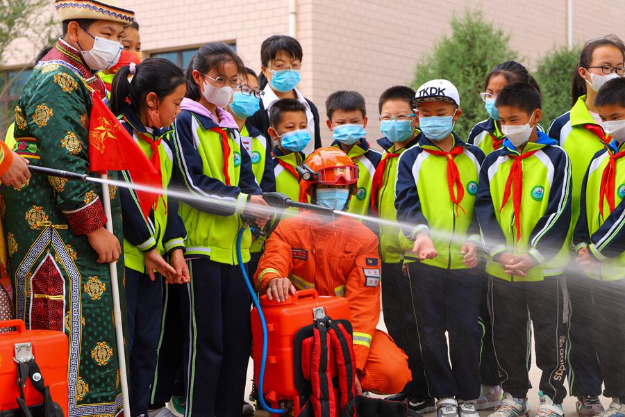 一名小學生在森林消防員的指導下操作森林滅火裝備。裴亮攝