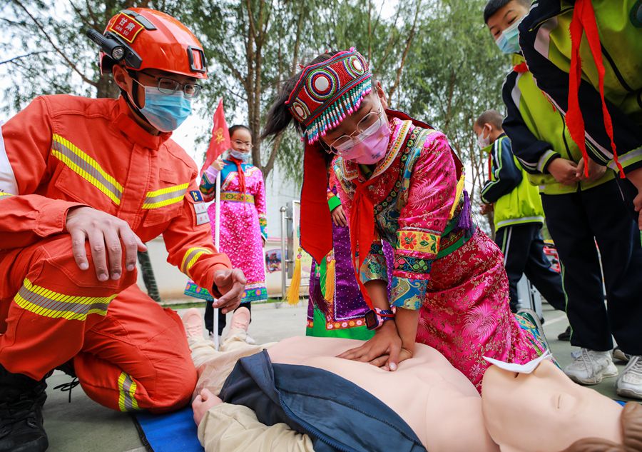 一名小學生在森林消防員的指導下學習心肺復蘇技能。張小軍攝