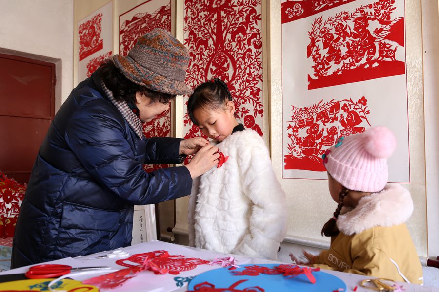 給小朋友佩戴兔元素剪紙作品。盤小美攝