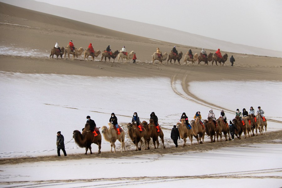 游客在甘肅省敦煌市鳴沙山月牙泉景區游覽。張曉亮攝