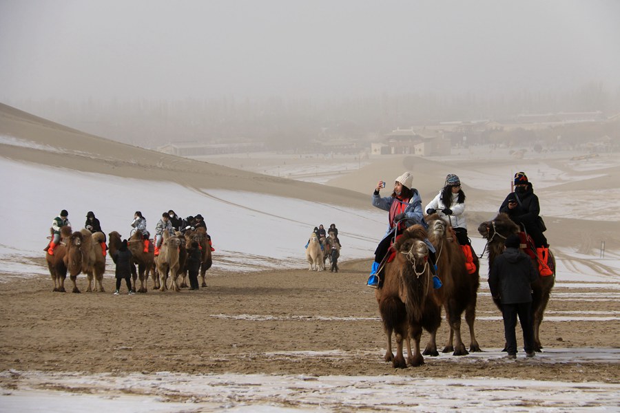 游客在甘肅省敦煌市鳴沙山月牙泉景區游覽。張曉亮攝