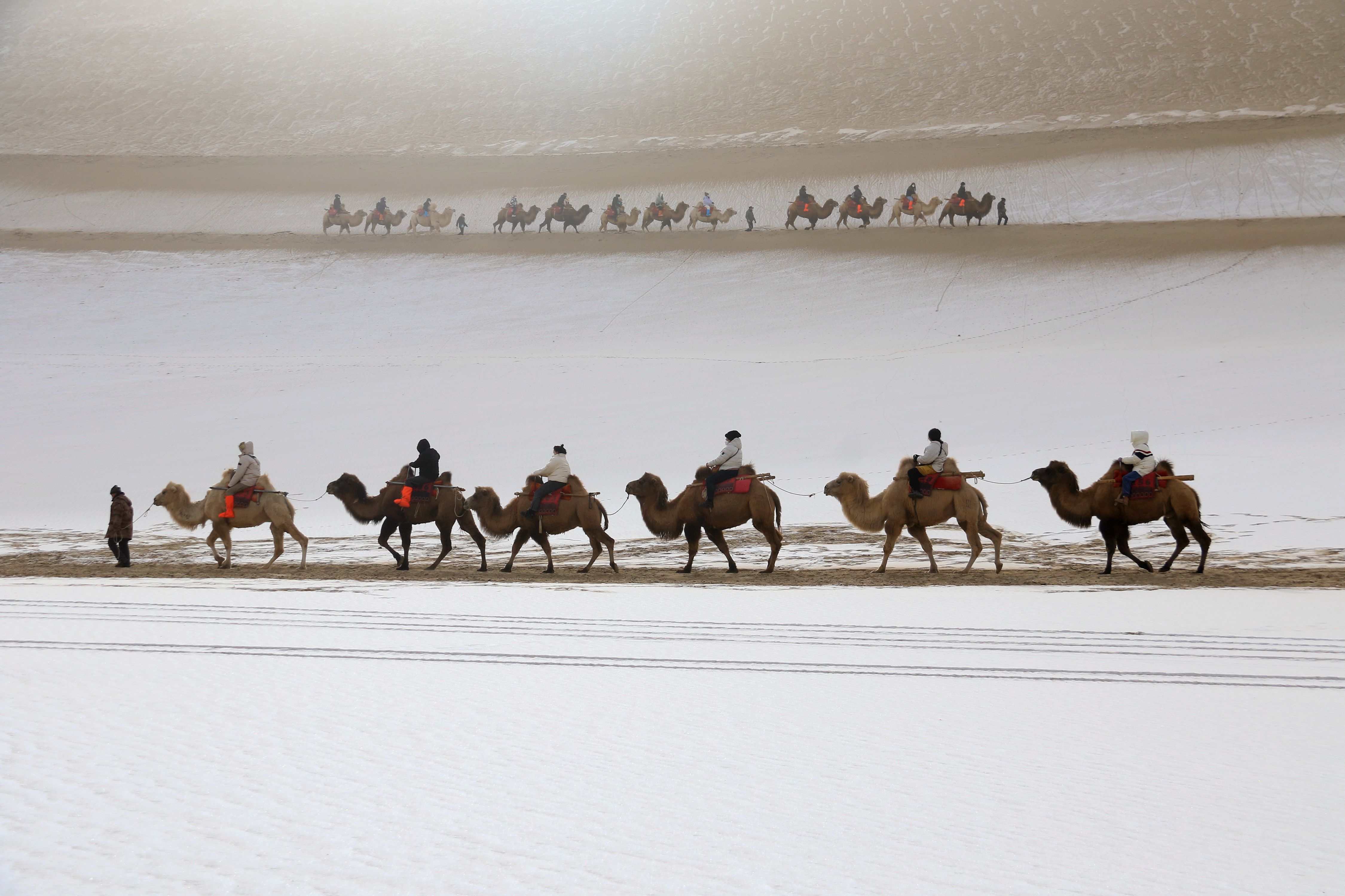 游客在甘肅省敦煌市鳴沙山月牙泉景區游覽。張曉亮攝
