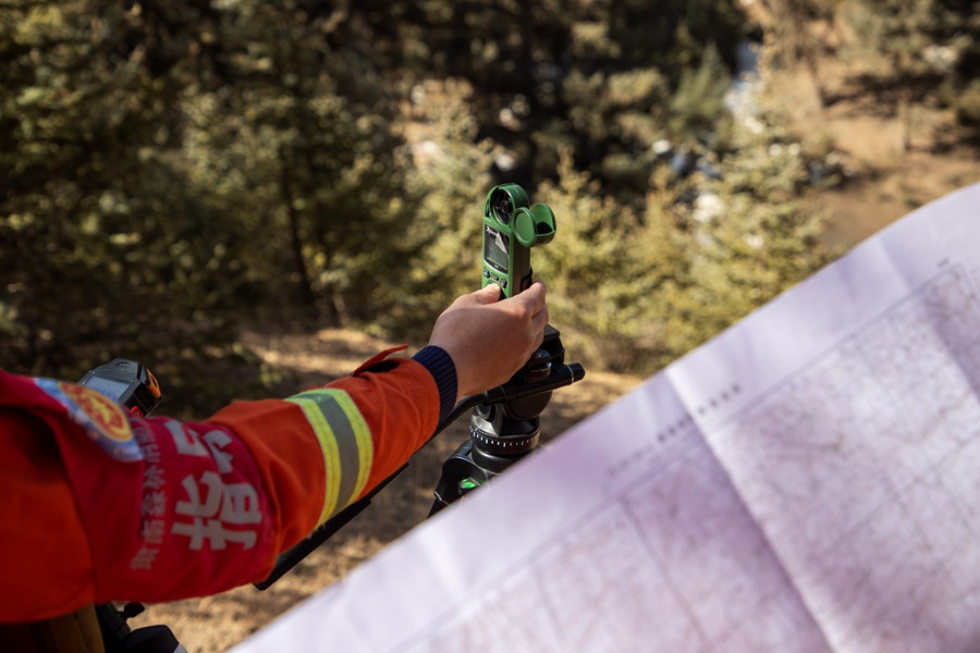 森林消防員利用測風儀進行風力風向判定。王威攝