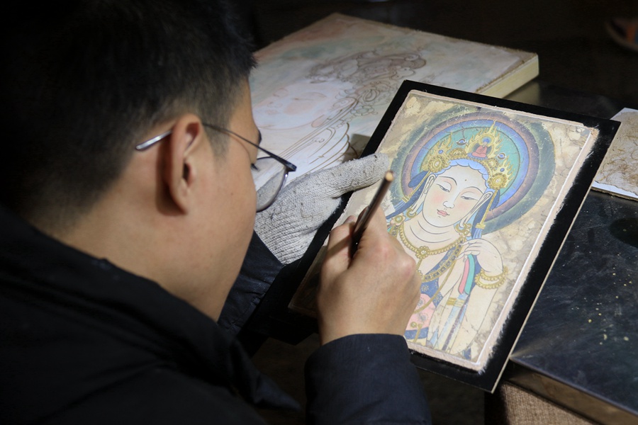 泥板畫藝人在敦煌夜市繪制泥板畫作品。張曉亮攝