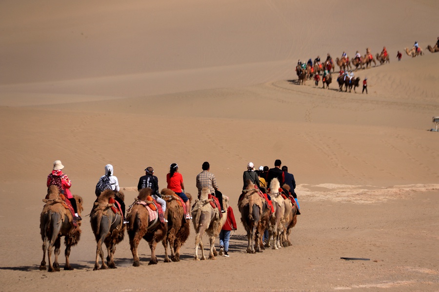 2023年5月11日，游客在甘肅省敦煌市鳴沙山月牙泉景區游覽。張曉亮攝