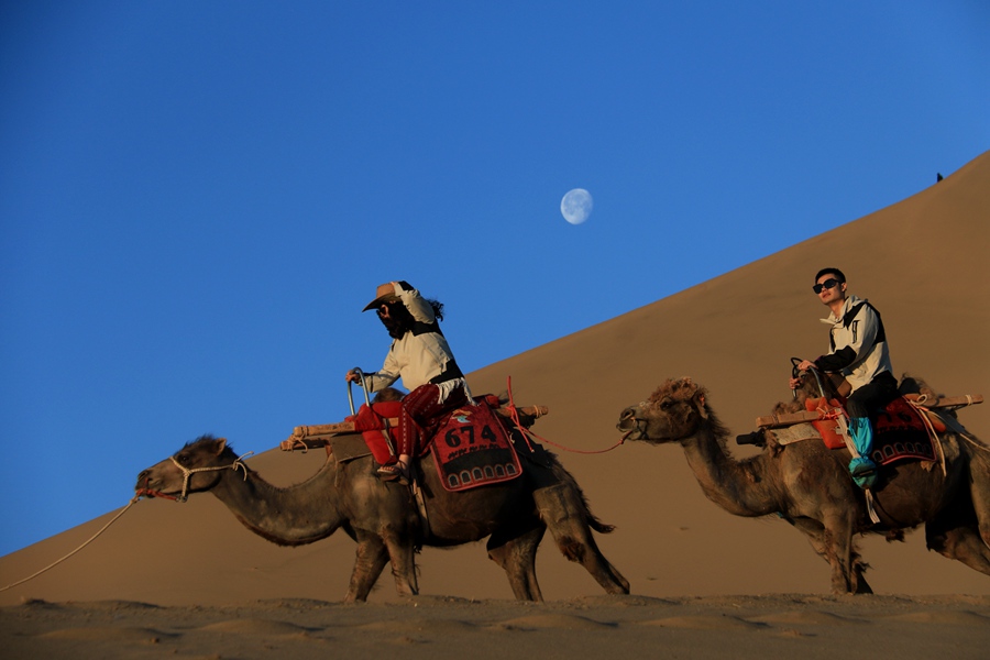 6月7日清晨，游客在甘肅省敦煌市鳴沙山月牙泉景區游覽。張曉亮攝