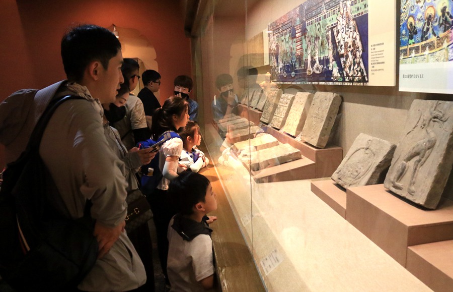 暑假期間，小朋友在家長的陪伴下，在敦煌市博物館參觀文物展。張曉亮攝