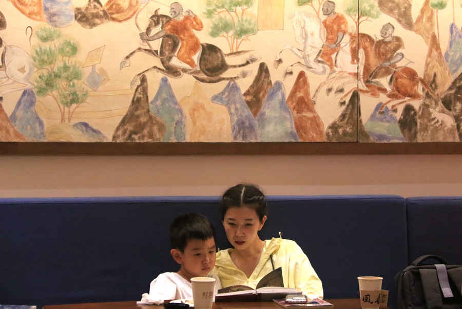 在甘肅省敦煌書局，小朋友在家長的陪伴下閱讀圖書。張曉亮攝