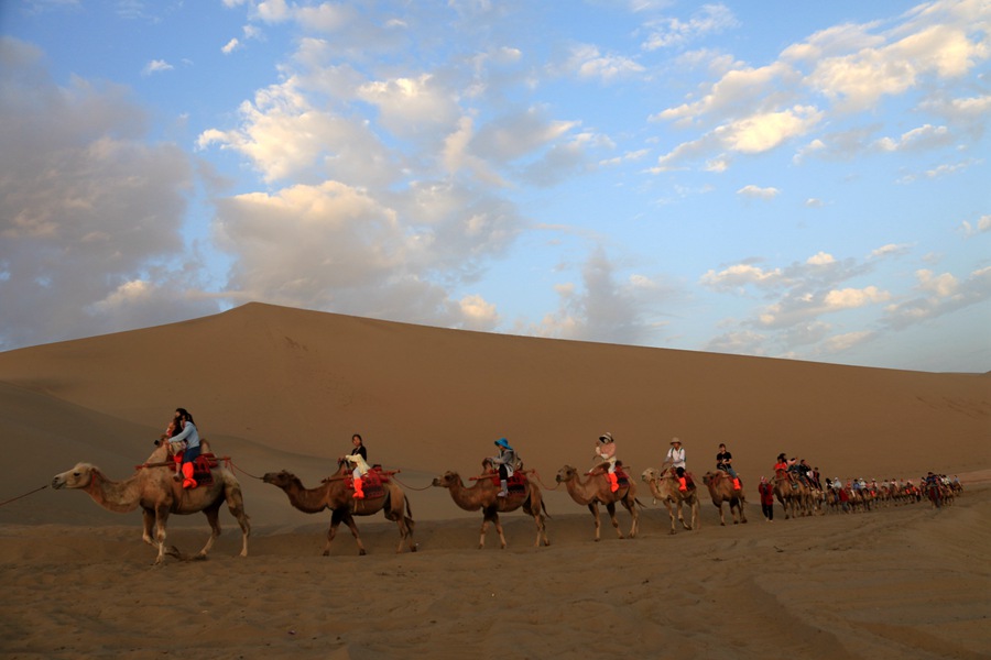 雨后清晨，游客在甘肅省敦煌市鳴沙山月牙泉景區游覽。張曉亮攝