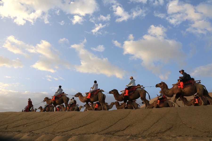 雨后清晨，游客在甘肅省敦煌市鳴沙山月牙泉景區游覽。張曉亮攝