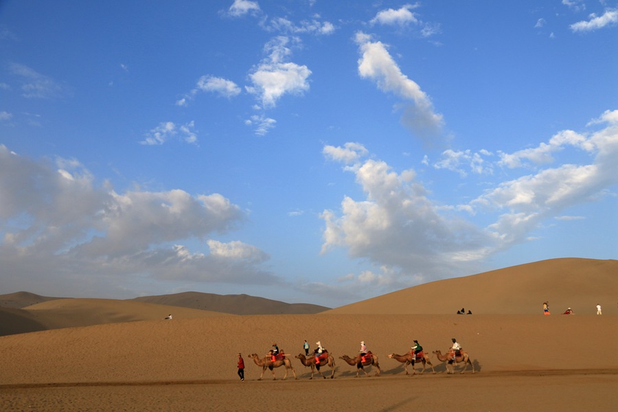 雨后清晨，游客在甘肅省敦煌市鳴沙山月牙泉景區游覽。張曉亮攝