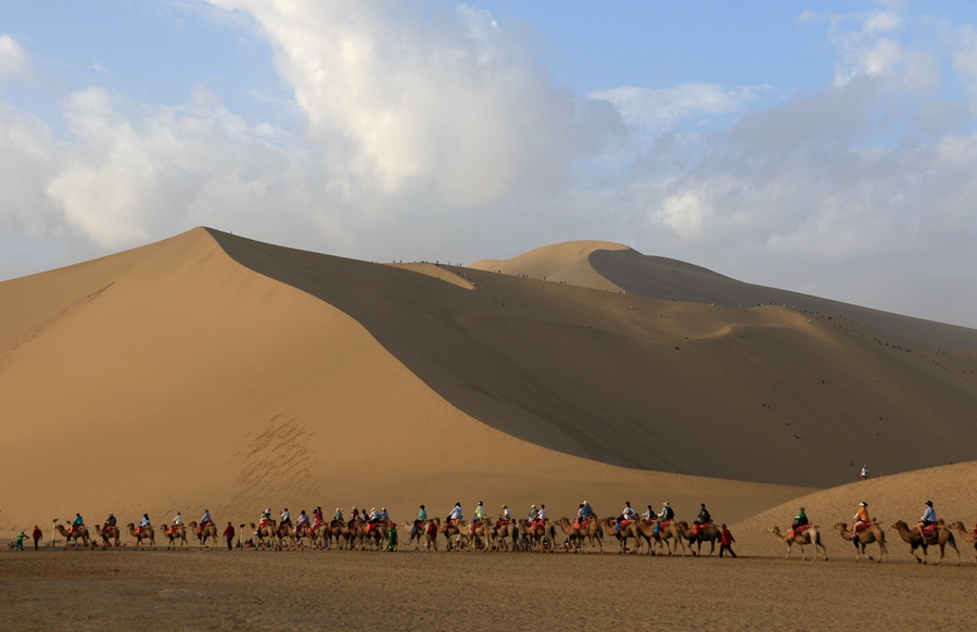 雨后清晨，游客在甘肅省敦煌市鳴沙山月牙泉景區游覽。張曉亮攝