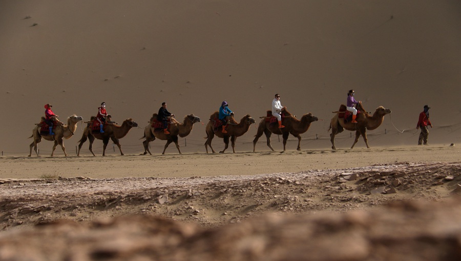 游客在甘肅省敦煌市鳴沙山月牙泉景區游覽。張曉亮攝 