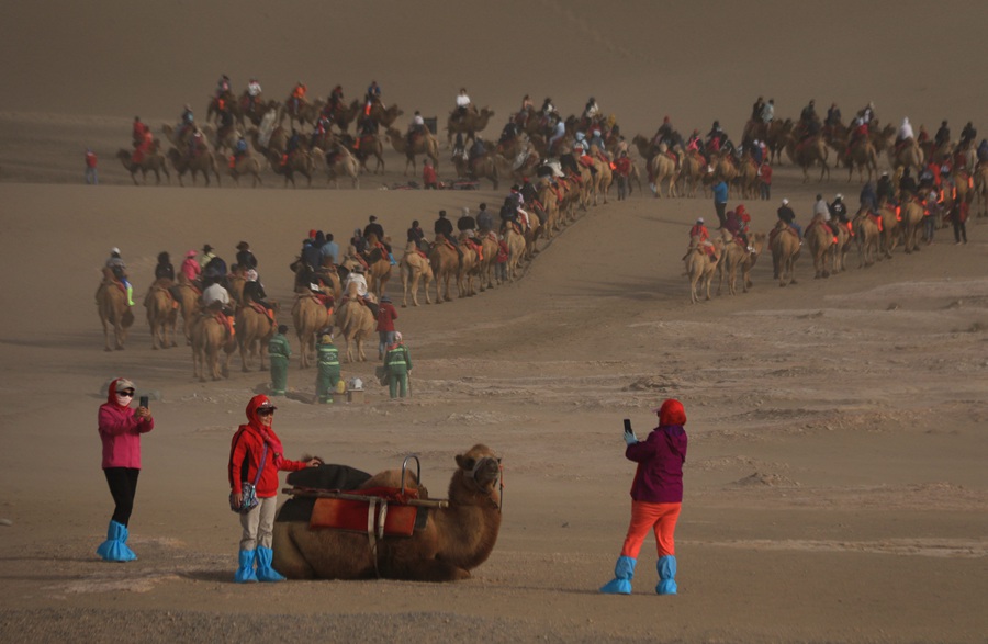 游客在甘肅省敦煌市鳴沙山月牙泉景區游覽。張曉亮攝
