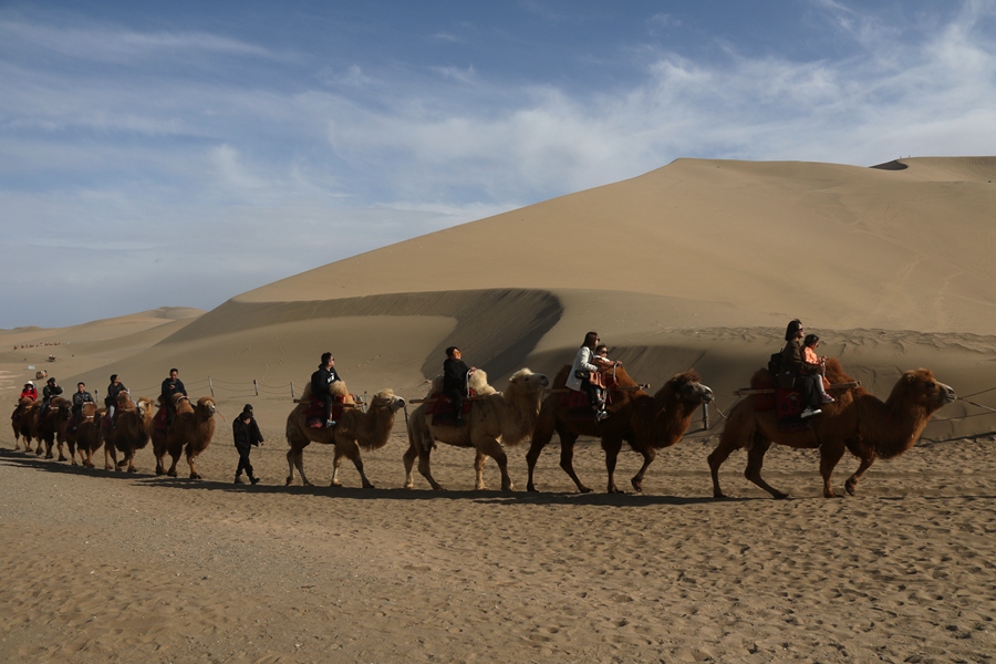 3月24日，游客在甘肅省敦煌市鳴沙山月牙泉景區游覽。張曉亮攝