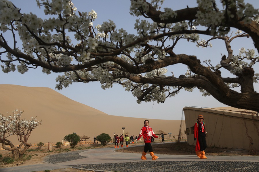 游客在甘肅省敦煌市鳴沙山月牙泉景區游覽。張曉亮攝