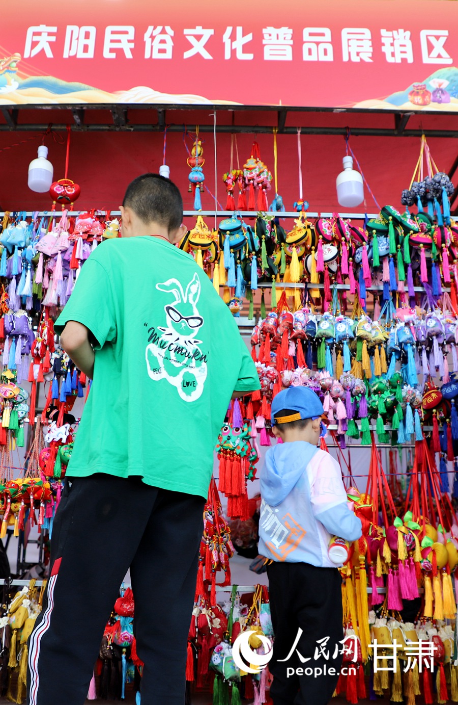在慶陽民俗文化普品展銷區，色彩艷麗、做工精湛的香包吸引了眾多市民游客駐足。人民網記者 邵蘭攝