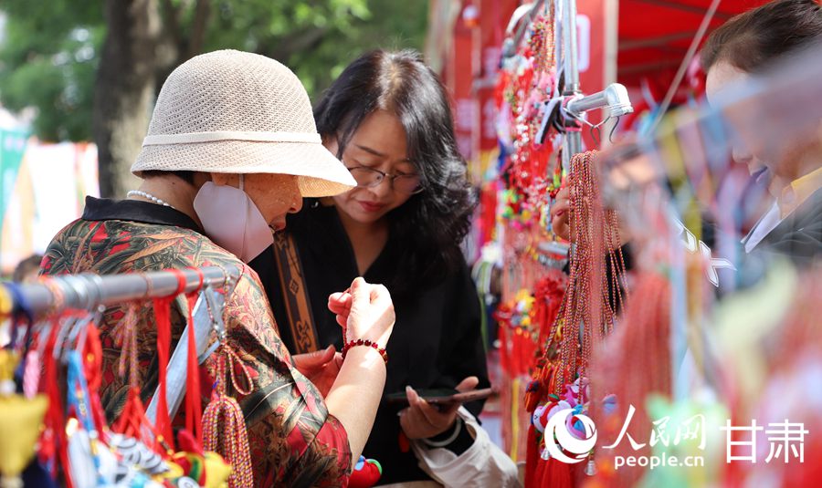 在慶陽民俗文化普品展銷區，色彩艷麗、做工精湛的香包吸引了眾多市民游客駐足。人民網記者 邵蘭攝