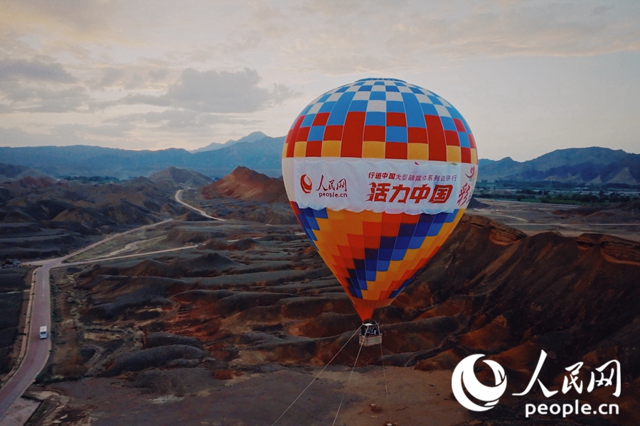 熱氣球在七彩丹霞上升起。人民網 李根攝