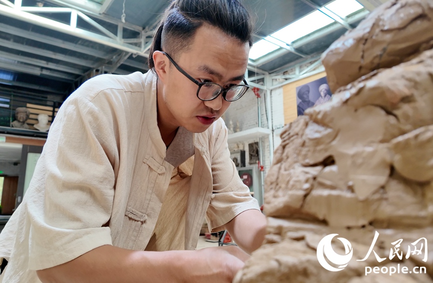 尤路平正在專心制作泥塑。人民網 李根攝