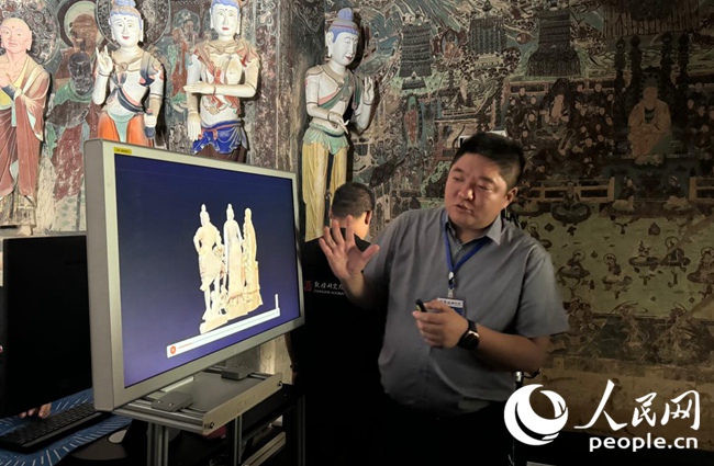 敦煌研究院文物數字化研究所副所長丁小勝向人民網“行進中國”甘肅調研采訪團介紹數字文物保護技術。人民網記者 王金雪攝