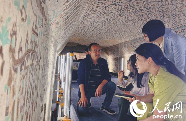 敦煌研究院文物保護技術服務中心副主任水碧紋向人民網“行進中國”甘肅調研采訪團介紹壁畫修復技術。人民網記者 趙雯攝