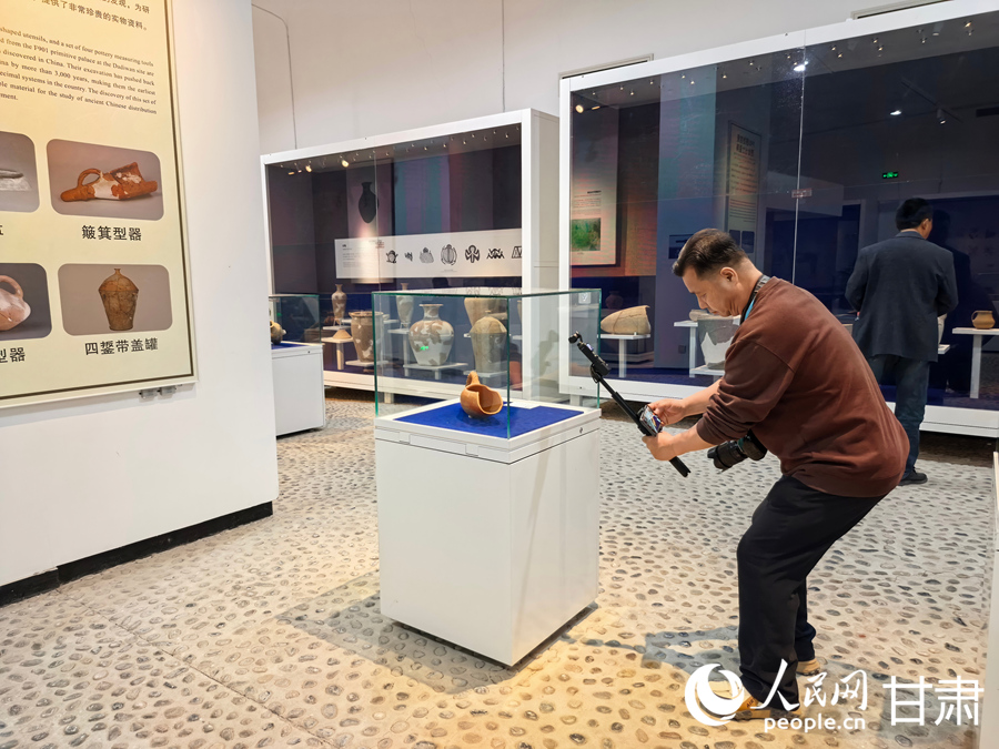 游客在大地灣博物館參觀拍攝。