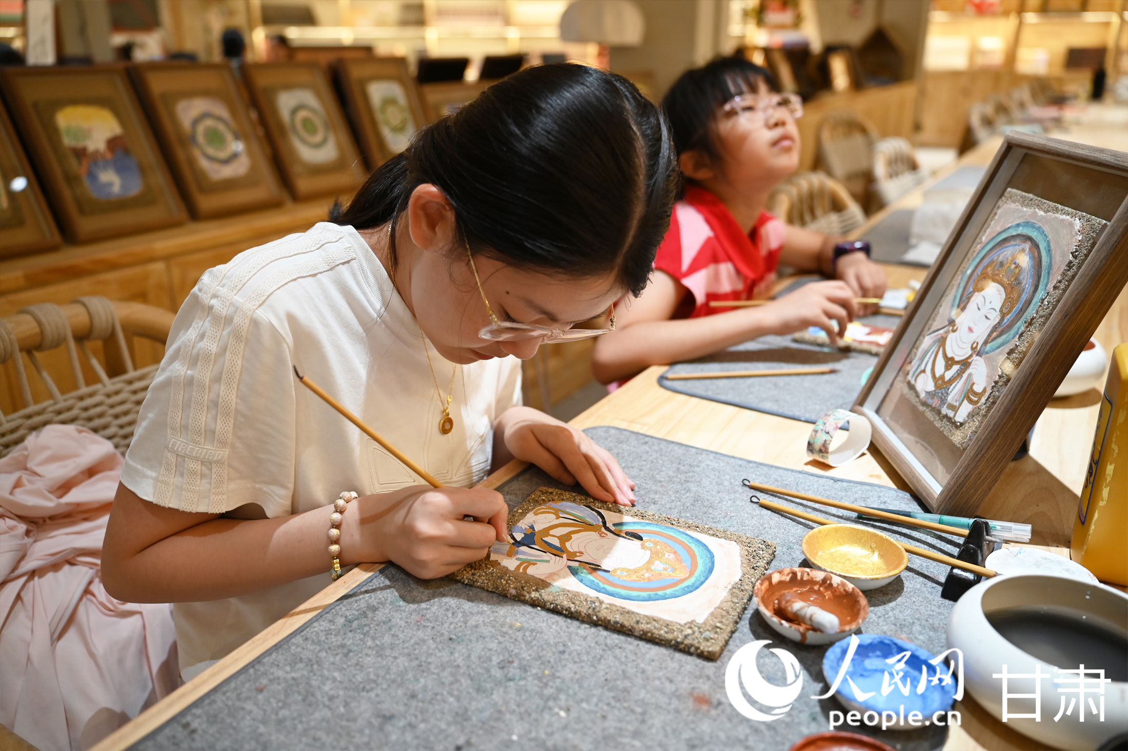 一名學生在敦煌印局臨摹莫高窟壁畫中的“美人菩薩”。人民網 席娟娟攝