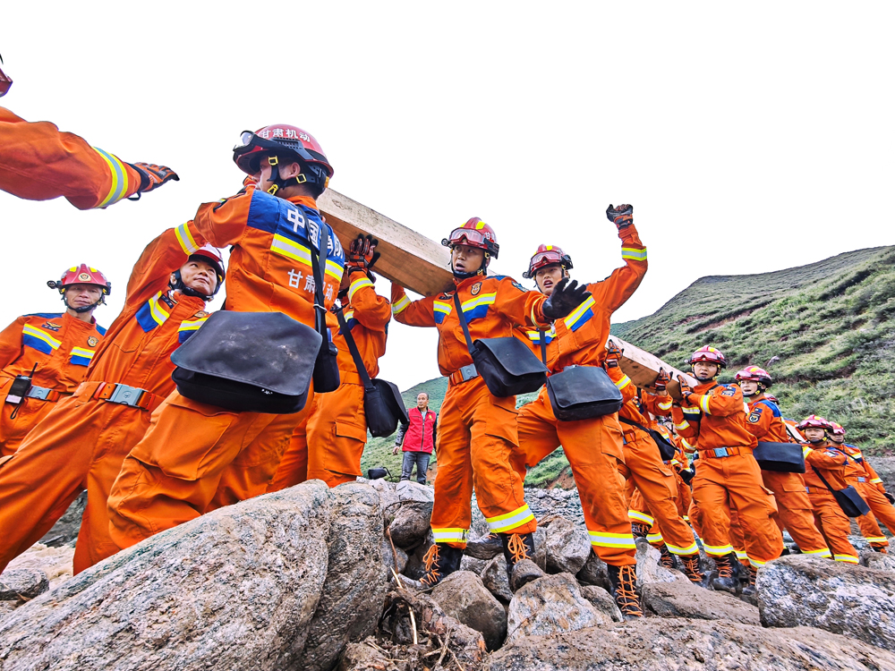 8月9日，甘肅省森林消防總隊在馬坡鄉舊莊溝村沿河道繼續搜尋被困人員途中搭建臨時木橋。張巍權 攝