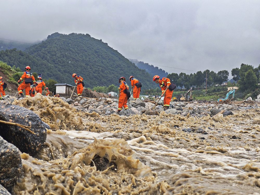 8月9日凌晨，甘肅省森林消防總隊在馬坡鄉舊莊溝村沿河道搜尋被困人員。張巍權 攝