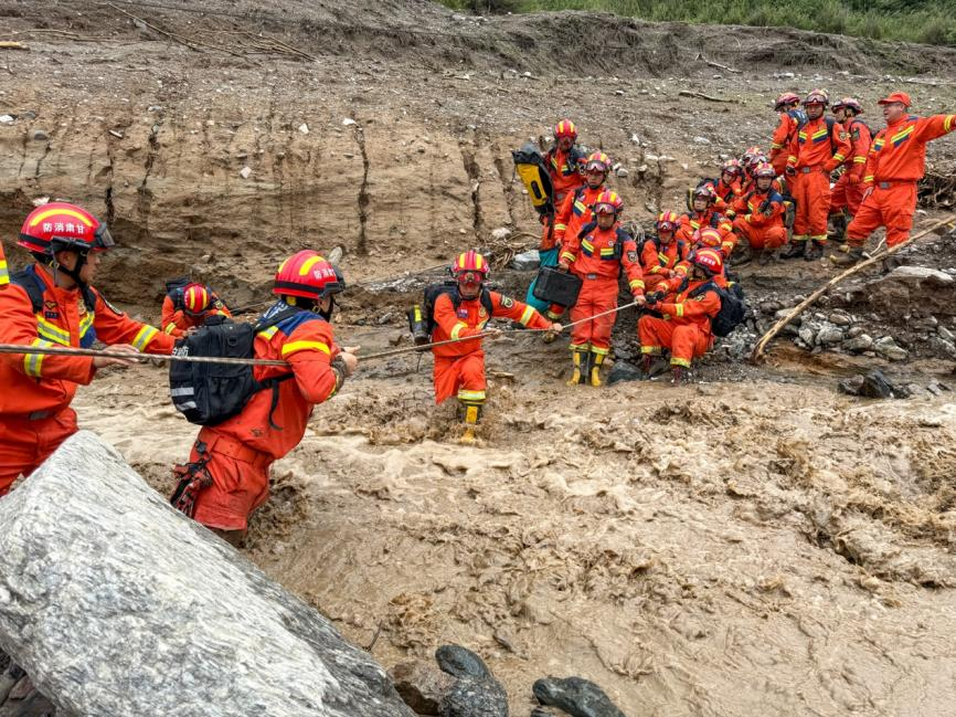 8月8日下午，受強降雨影響，榆中縣馬蓮灘村五社道路損毀嚴重，消防救援力量正在通過繩索橫渡前往救援。甘肅消防供圖