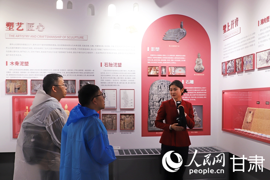 講解員向游客講解塑像過程。人民網記者 米媛攝