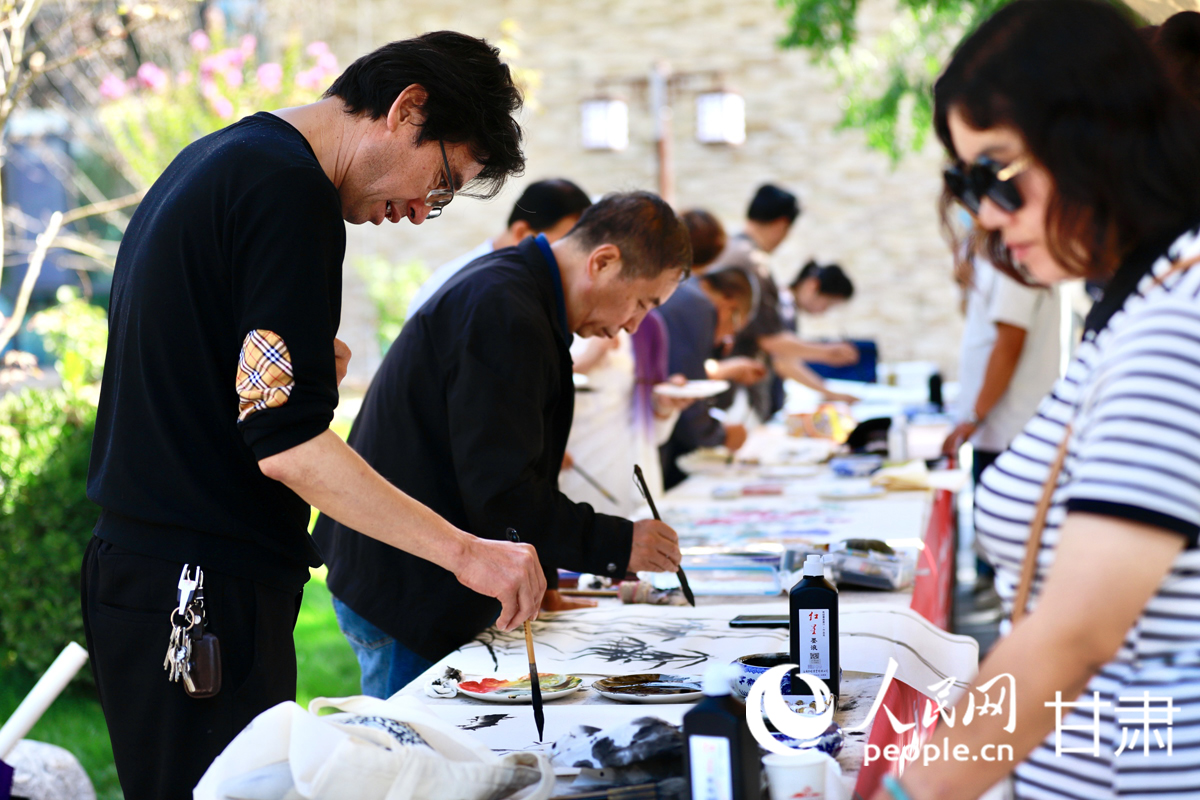 文化體驗區內，游客正觀摩書畫家創作，并參與即興創作互動。人民網記者 焦隆攝