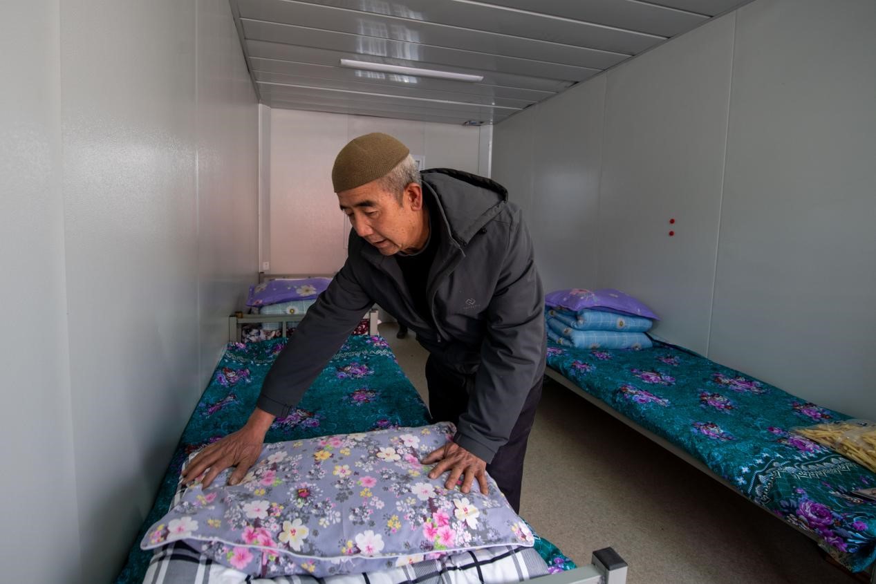 12月22日，在積石山縣劉集鄉陶家村，已經入住臨時安置箱式房的地震受災群眾正在整理被褥。人民網記者 翁奇羽攝